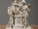 sculpture représentant un groupe de personnes, posée sur un socle posé sur une table