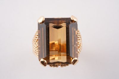 un gros plan d'une bague sertie d'une grosse pierre verte