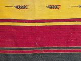 an old striped rug with a red, yellow, and black design