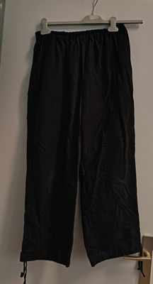 a black pants hanging on a hanger in a room