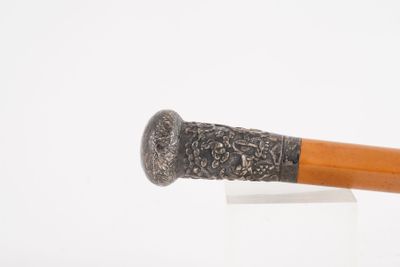 un bâton en bois avec une poignée en métal sur une surface blanche
