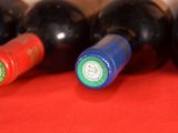 several bottles of wine are lined up on a red cloth