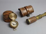 un petit coffret en bois contenant une boussole et d'autres objets, posé sur une table