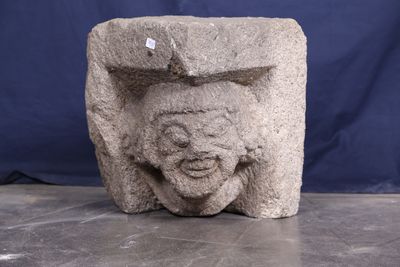 une sculpture en pierre représentant un visage, posée sur une table