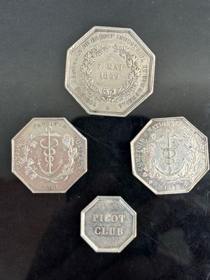 four different coins are on display in a glass case