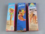 three boxes of barbies are lined up on a table