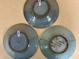 three blue plates are sitting on top of a table