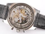 a close up of a watch on a white surface