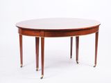 une table de salle à manger ovale avec quatre pieds et un plateau en bois