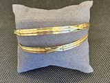 une paire de bracelets en or posés sur un oreiller