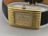 a gold wrist watch with a blue diamond on it