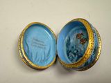 a small blue and gold box with a picture on it