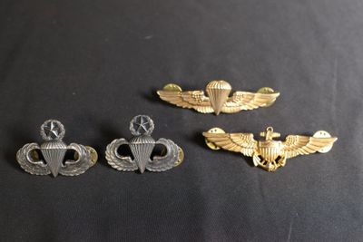 trois insignes militaires sur une surface noire avec un fond noir