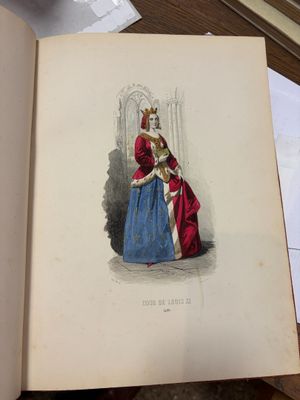 un livre ouvert sur lequel figure le dessin d'une femme en robe bleue
