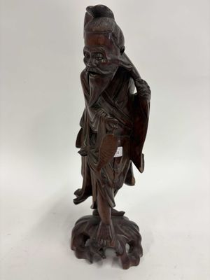 une statue en bois représentant un homme avec un oiseau sur l'épaule