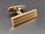 a pair of gold cufflinks sitting on a table