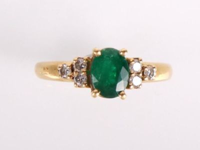 bague ovale en émeraude et diamant sur fond blanc