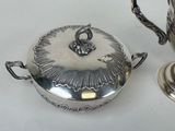a silver tea pot and a silver teapot on a table