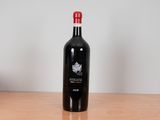 a bottle of red wine sitting on a wooden table