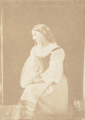 une photographie sépia représentant une femme assise sur une chaise