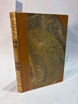 un vieux livre posé sur une table blanche, à côté d'une feuille de papier