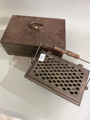 une petite boîte en métal munie d'une poignée et d'une autre poignée