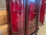 une armoire rouge avec un plateau en marbre et une porte en verre
