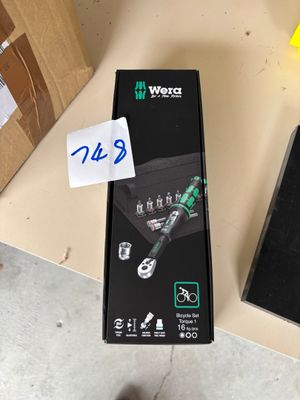 someone standing next to a box of tools on a table