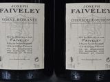 two bottles of wine sitting on top of a table next to each other