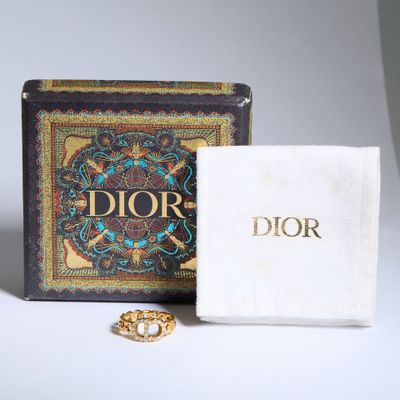 un gros plan d'une boîte sur laquelle est posée une bague, à côté d'un livre