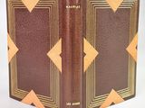 un vieux livre à la couverture marron posé sur une table blanche