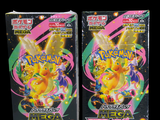 two packs of pokemon trading cards are shown on a black background