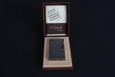 a small black wallet in a box on a black surface