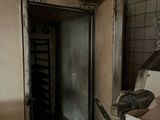 an open door in a dirty kitchen with a dirty stove