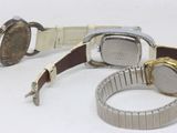 two watches are sitting next to each other on a white surface