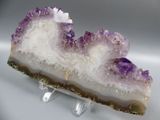 purple and white slice of amethorate sitting on a clear stand