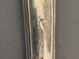 a silver spoon with a handle on a table