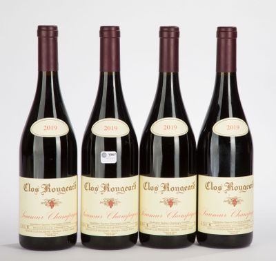 three bottles of red wine sitting next to each other on a white surface