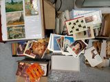 une pile de cartes postales posée par terre à côté d'un ordinateur portable