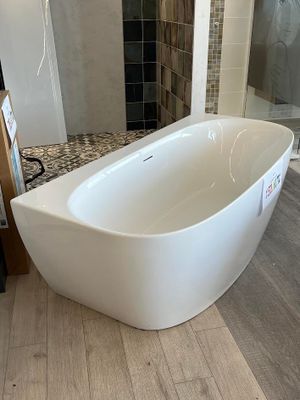 une baignoire blanche installée dans une salle de bains, à côté d'une douche à l'italienne