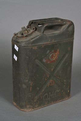 an old metal canister with a metal handle on a gray surface