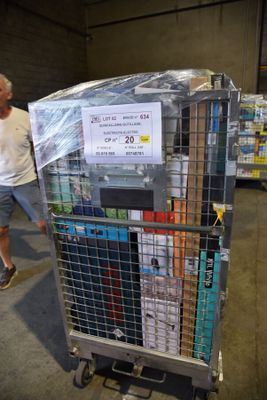 a man that is pushing a cart with a lot of books