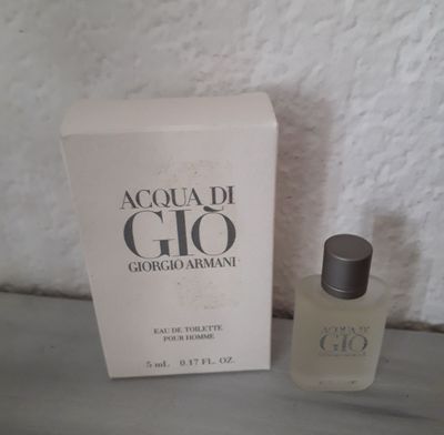 an image of a bottle of perfume sitting next to a box