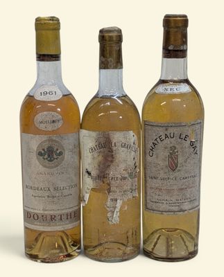 trois bouteilles de vin posées les unes à côté des autres sur une surface blanche