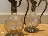 two glass vases sitting on a table next to each other