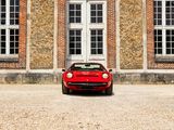 a red sports car parked in front of a brick building