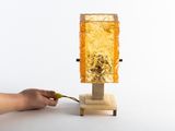 a person that is cutting a piece of wood with a knife