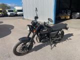 une moto noire garée devant un bâtiment