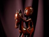 statue représentant un homme à cheval posée sur une table en bois