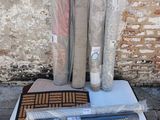 plusieurs rouleaux de tissu, un rouleau de moquette et un rouleau de toile posés par terre